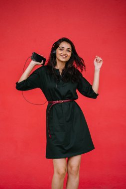 Bir güzel, Genç ve çekici Hint Asyalı kadın bir yeşil elbise ve kırmızı bir arka plan kırmızı kemer Studio portresi