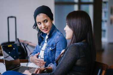 Müslüman bir Orta Doğulu kadın Çinli bir meslektaşıyla iş görüşmesi yapıyor..