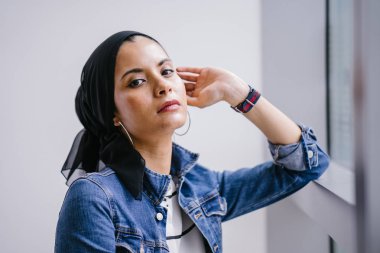 Genç, zarif ve çekici Malezyalı Müslüman kadın gün boyunca elbise ve kot ceket giyiyor..