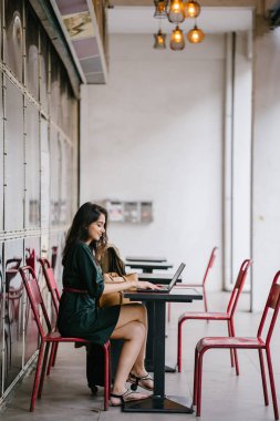 genç üniversite öğrencisi (Hint Asyalı kadın) eğitim ve gün boyunca dizüstü bilgisayar bir masa başında çalışma