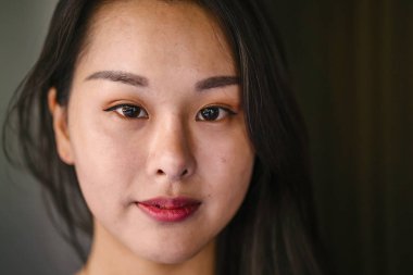 Kendinden emin, genç, güzel ve kendinden emin Asyalı bir kadının portresi.