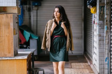 Hint Asyalı kadın Genç, uzun boylu, ince ve zarif bir portre için poz veriyor. O rahat ve şık rahat giysiler giyiyor ve bir adamın ceketi omuzları üzerinde bol dökümlü vardır. 