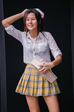 Kırmızı Santa şapka genç ve güzel Çinli Asyalı kadın portresi. O sevilen bir hediye üzerine tutan gibi mutlu gülümsüyor.