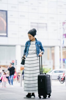 Genç, uzun, ince ve zarif bir Malezyalı Müslüman 'ın portresi şehrin kalabalık bir caddesinde duruyor..