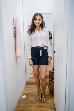 Trying dışarı giyim moda mağaza montaj odasında bir genç, uzun boylu, güzel ve zarif Hint Asyalı kadın portresi.