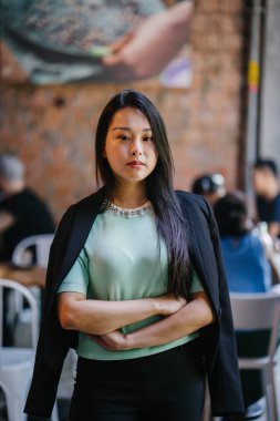 Gündüz vakti genç, seksi ve çekici bir Asyalı kadının portresi. O nane yeşili bir kazak giyiyor.