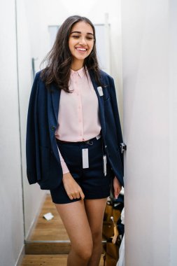 Yeni giyim moda salonu bir alışveriş merkezinde bir montaj odasında çalışıyor bir genç ve güzel Hint Asyalı kadın portresi.