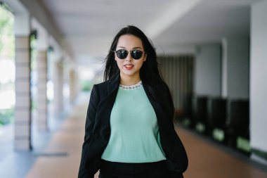 Gündüz vakti genç, seksi ve çekici bir Asyalı kadının portresi. O nane yeşili bir kazak giyiyor.