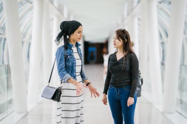 Gündüz vakti köprüde farklı etnik kökenlere sahip iki arkadaş. Biri Malezyalı Müslüman bir kadın, diğeri de Çinli bir Asyalı. İkisi de genç, enerjik ve çekici..