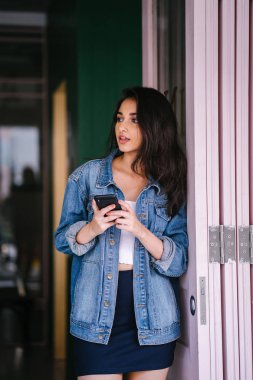 Güzel, uzun boylu, zarif ve genç Hintli Asyalı kadın manifatura onun akıllı portresi. O bir retro Kot ceket giyiyor 