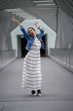 Genç, zarif ve çekici Malezyalı Müslüman kadın gün boyunca elbise ve kot ceket giyiyor..