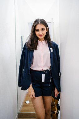 Yeni giyim moda salonu bir alışveriş merkezinde bir montaj odasında çalışıyor bir genç ve güzel Hint Asyalı kadın portresi.