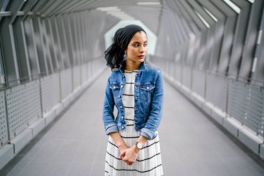 Gün boyunca güzel bir köprüde tek başına duran uzun boylu, genç, zarif ve çekici Malezyalı Müslüman bir kadının portresi..