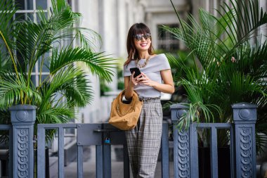 Çekici, kendine güvenen ve başarılı bir Çinli Asyalı kadının portresi. Akıllı telefonunu tutuyor. 
