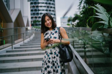 O Singapur (Asya 'da bir şehir) gün boyunca taş adımlarla oturur gibi bir Çinli Asyalı kadın metin ve mesaj onu Smartphone kullanıyor. O genç, çekici ve hayat dolu