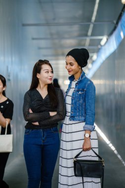 Gündüz vakti köprüde farklı etnik kökenlere sahip iki arkadaş. Biri Malezyalı Müslüman bir kadın, diğeri de Çinli bir Asyalı. İkisi de genç, enerjik ve çekici..