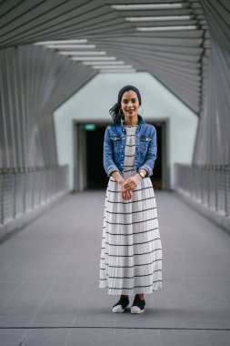 Genç, zarif ve çekici Malezyalı Müslüman kadın gün boyunca elbise ve kot ceket giyiyor..