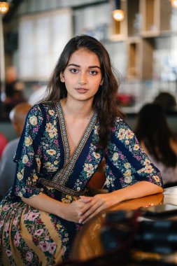 portre baş shot, kendine güvenen, Genç ve çekici Hint Asya kız sıcak aydınlatılmış bir trendy Cafe