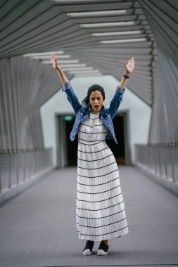 Genç, zarif ve çekici Malezyalı Müslüman kadın gün boyunca elbise ve kot ceket giyiyor..