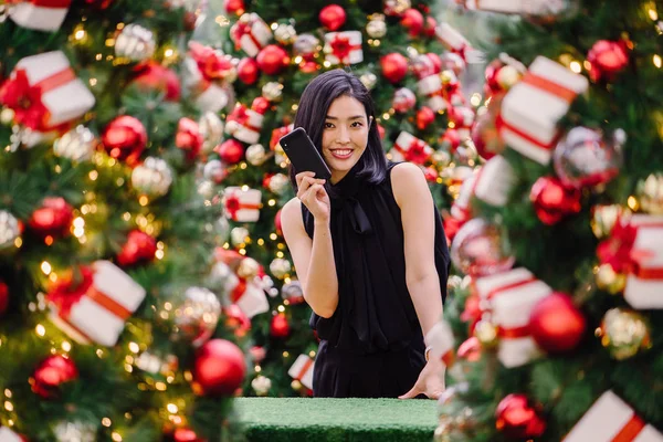 Güzel ve genç bir Kore Asya kadın portresi beholds ve harikası Noel süsleri smiling