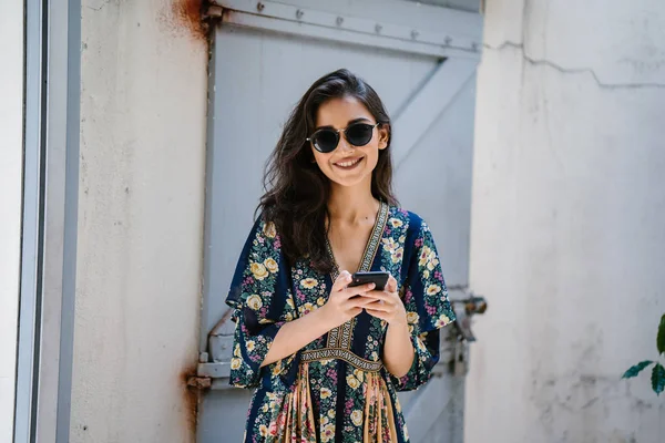 여자의 초상화는 매력적이 아시아 드레스와 그녀의 스마트폰으로 선글라스 — 스톡 사진