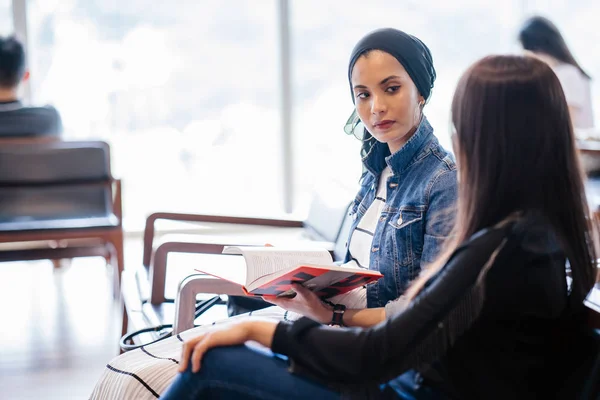 Dos Jóvenes Amigas Sentadas Banco Leyendo Libros Discutiendo Una Una —  Fotos de Stock