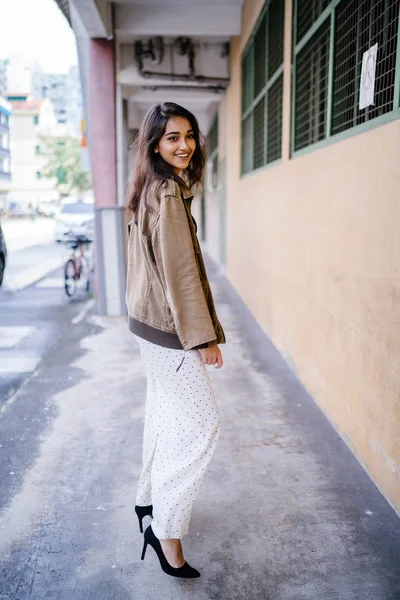 Gün boyunca bir geçit Asya'da bir şehirde yürürken bir uzun boylu, güzel, ince ve zarif Hint Asyalı kadın portresi. O zarif giyindi ve bir ceket omuzları üzerinde bol dökümlü vardır.