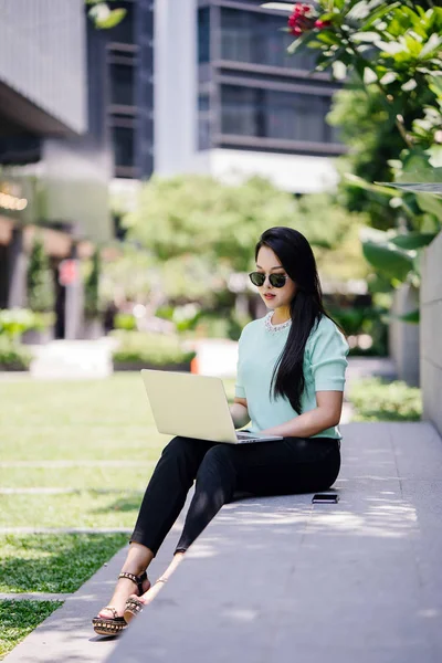 Genç ve çekici bir Asyalı kadın öğrenci oturur ve gün boyunca bir üniversite kampüsünde onu dizüstü bilgisayar üzerinde çalışır. O gelişigüzel giyinmiş ve o çalışmalar gibi güneş gözlüğü bir çift var. 