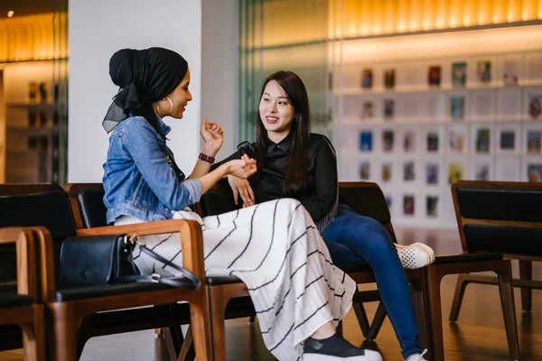 İki bayan arkadaş bankta oturup sohbet ediyorlar. Biri Çinli, diğeri Müslüman.