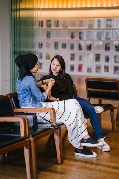 Duas Amigas Sentadas Banco Conversando Uma Delas Chinesa Outra Muçulmana — Fotografia de Stock