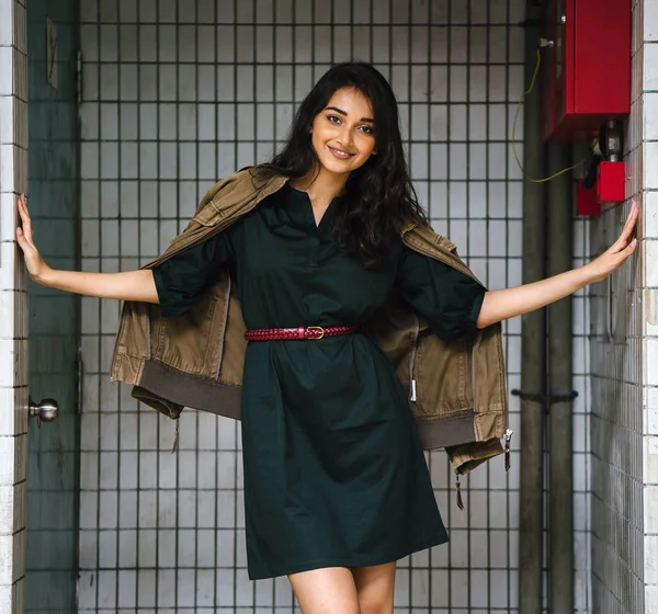 Hint Asyalı kadın Genç, uzun boylu, ince ve zarif bir portre için poz veriyor. O rahat ve şık rahat giysiler giyiyor ve bir adamın ceketi omuzları üzerinde bol dökümlü vardır. 