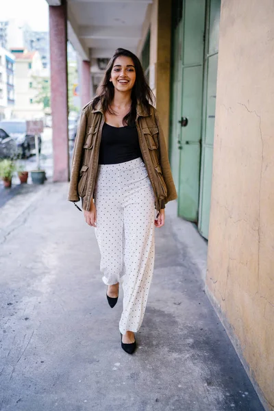 Gün boyunca bir geçit Asya'da bir şehirde yürürken bir uzun boylu, güzel, ince ve zarif Hint Asyalı kadın portresi. O zarif giyindi ve bir ceket omuzları üzerinde bol dökümlü vardır.