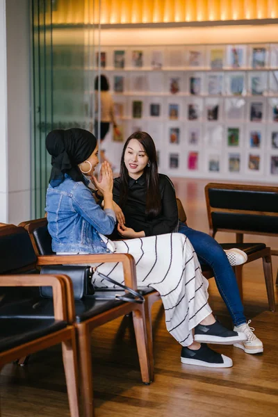 Twee Vrouwelijke Vrienden Zitten Bank Chatten Een Van Hen Chinees — Stockfoto