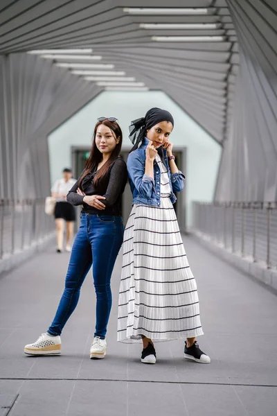Gündüz vakti köprüde farklı etnik kökenlere sahip iki arkadaş. Biri Malezyalı Müslüman bir kadın, diğeri de Çinli bir Asyalı. İkisi de genç, enerjik ve çekici..