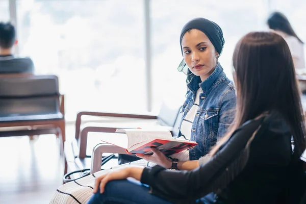 Duas Jovens Amigas Sentadas Banco Lendo Livros Discutindo Deles Uma — Fotografia de Stock