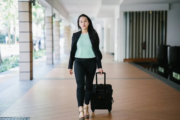 一位年轻的亚洲妇女正在拉她的手提箱行李 她迷人 穿着时尚 — 图库照片