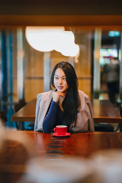 一个年轻 优雅和美丽的亚洲妇女坐在户外露天咖啡馆 从红茶具中享用热茶的肖像 — 图库照片