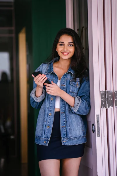 Güzel, uzun boylu, zarif ve genç Hintli Asyalı kadın manifatura onun akıllı portresi. O bir retro Kot ceket giyiyor 