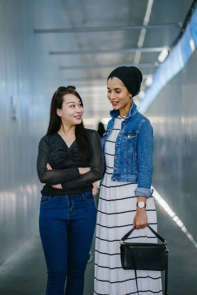 Gündüz vakti köprüde farklı etnik kökenlere sahip iki arkadaş. Biri Malezyalı Müslüman bir kadın, diğeri de Çinli bir Asyalı. İkisi de genç, enerjik ve çekici..