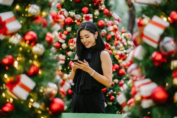 Güzel ve genç bir Kore Asya kadın portresi beholds ve harikası Noel süsleri smiling