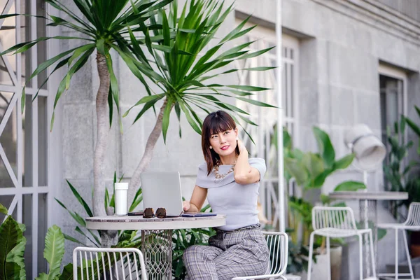 Modern dizüstü bilgisayar kullanarak çekici, kendine güvenen ve başarılı bir Çinli Asyalı kadının portresi