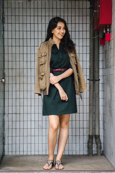Hint Asyalı kadın Genç, uzun boylu, ince ve zarif bir portre için poz veriyor. O rahat ve şık rahat giysiler giyiyor ve bir adamın ceketi omuzları üzerinde bol dökümlü vardır. 