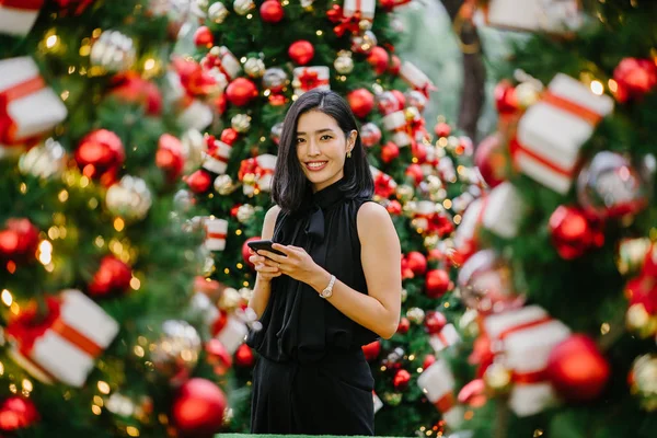 Güzel ve genç bir Kore Asya kadın portresi beholds ve harikası Noel süsleri smiling