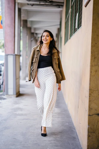 Gün boyunca bir geçit Asya'da bir şehirde yürürken bir uzun boylu, güzel, ince ve zarif Hint Asyalı kadın portresi. O zarif giyindi ve bir ceket omuzları üzerinde bol dökümlü vardır.