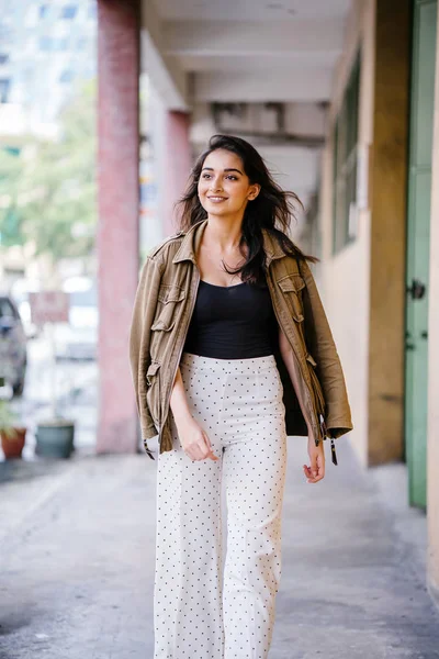 Gün boyunca bir geçit Asya'da bir şehirde yürürken bir uzun boylu, güzel, ince ve zarif Hint Asyalı kadın portresi. O zarif giyindi ve bir ceket omuzları üzerinde bol dökümlü vardır.