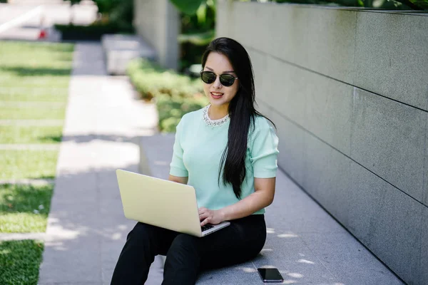 Genç ve çekici bir Asyalı kadın öğrenci oturur ve gün boyunca bir üniversite kampüsünde onu dizüstü bilgisayar üzerinde çalışır. O gelişigüzel giyinmiş ve o çalışmalar gibi güneş gözlüğü bir çift var. 