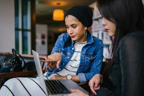 Müslüman bir Orta Doğulu kadın Çinli bir meslektaşıyla iş görüşmesi yapıyor..
