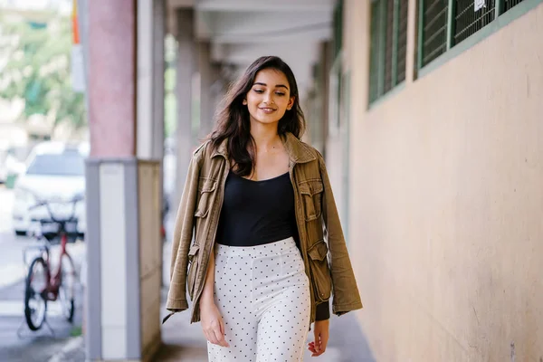 Gün boyunca bir geçit Asya'da bir şehirde yürürken bir uzun boylu, güzel, ince ve zarif Hint Asyalı kadın portresi. O zarif giyindi ve bir ceket omuzları üzerinde bol dökümlü vardır.