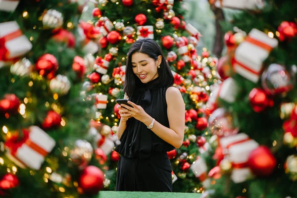 Güzel ve genç bir Kore Asya kadın portresi beholds ve harikası Noel süsleri smiling