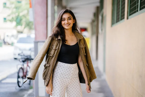 Gün boyunca bir geçit Asya'da bir şehirde yürürken bir uzun boylu, güzel, ince ve zarif Hint Asyalı kadın portresi. O zarif giyindi ve bir ceket omuzları üzerinde bol dökümlü vardır.